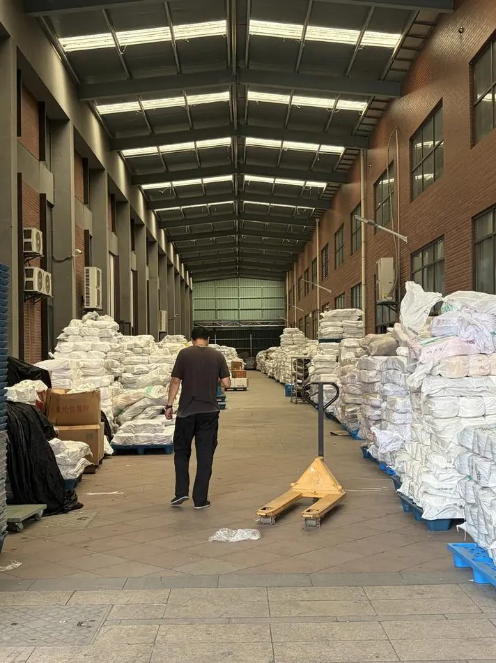 A warehouse aisle stacked with bales of finished socks