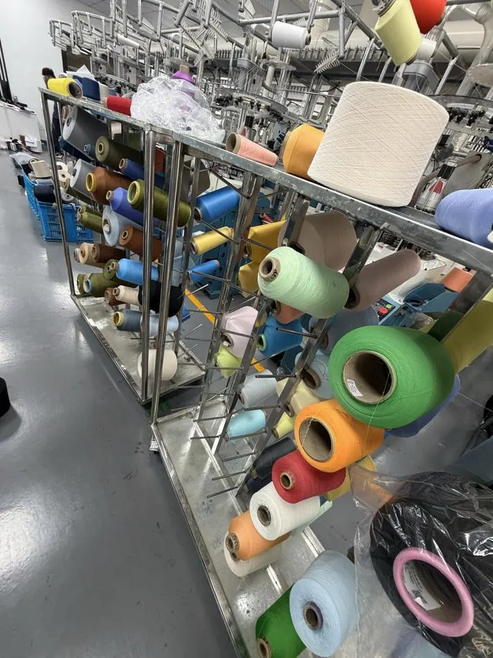 Racks of yarn cones in dozens of colours